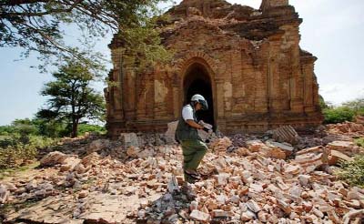 A photograper walks outside a collapsed pagoda after an earthquake in Bagan, Myanmar on Thursday.