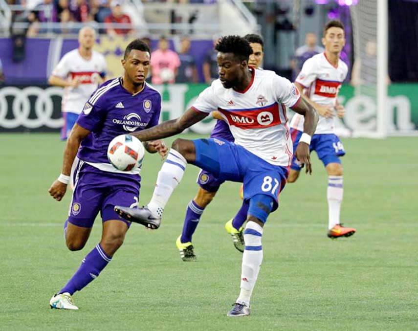 Toronto FC's Tosaint Ricketts (87) moves the ball past Orlando City's Tommy Redding, (left) during the first half of an MLS soccer game on Wednesday in Orlando, Fla.