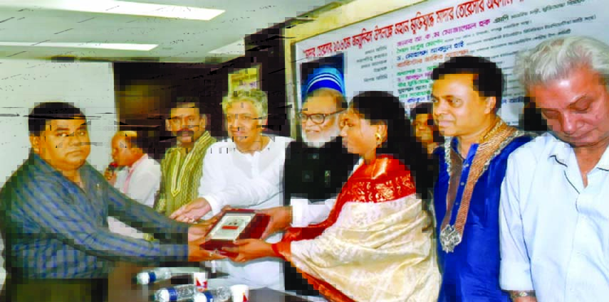 Liberation War Affairs Minister AKM Mozammel Haque handing over crest of honour to the Headmaster of the city's Rampura Ekramunnesa High School, Mazharul Islam Talukder for his contribution in education at the Jatiya Press Club organised recently marking