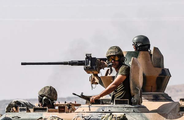 Turkish soldiers drive a tank to Syria from the border city of Karkamis in the Gaziantep region on Saturday.