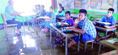 KHULNA: Students of Govt Madhobkathi Primary School in Dumuria Upazila are attending classes in inundated class room caused by recent downpour. This picture was taken yesterday.