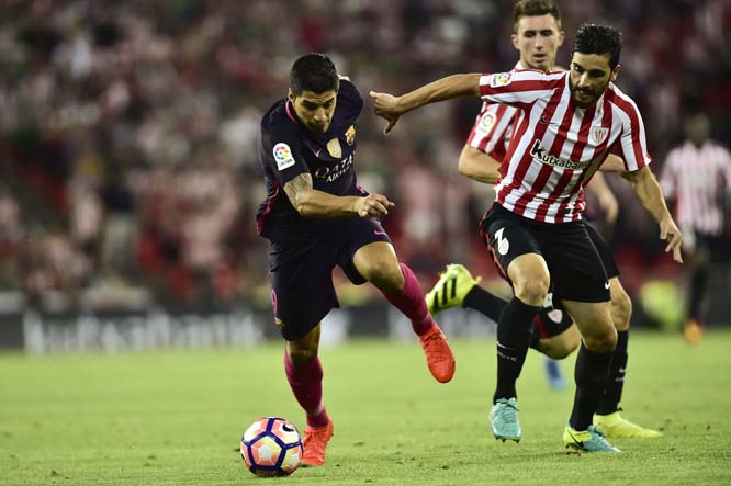 FC Barcelona's Luis Suarez (left) duels for the ball with Athletic Bilbao's Eneko Boveda during the Spanish La Liga soccer match between FC Barcelona and Athletic Bilbao, at San Mames stadium, in Bilbao, northern Spain on Sunday.