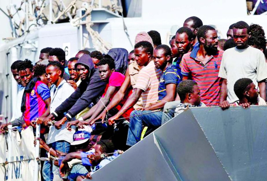 Migrants wait to disembark from the Italian Navy vessel Sfinge in the Sicilian harbour of Pozzallo, southern Italy on Wednesday.