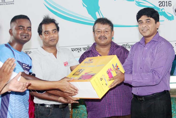 General Secretary of Dhaka Reporters Unity (DRU) Razu Ahmed (extreme right) handing over the award of the Man of the Match of the Walton-DRU Media Cup Football Tournament at the Shaheed (Captain) M Mansur Ali National Handball Stadium on Wednesday.