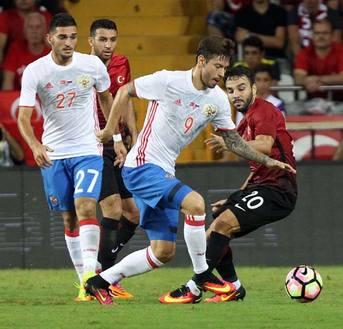 Turkey's Volkan Sen (right) and Fedor Smolov of Russia (center) fight for the ball during an international friendly soccer match between Turkey and Russia in Antalya, Turkey on Wednesday.