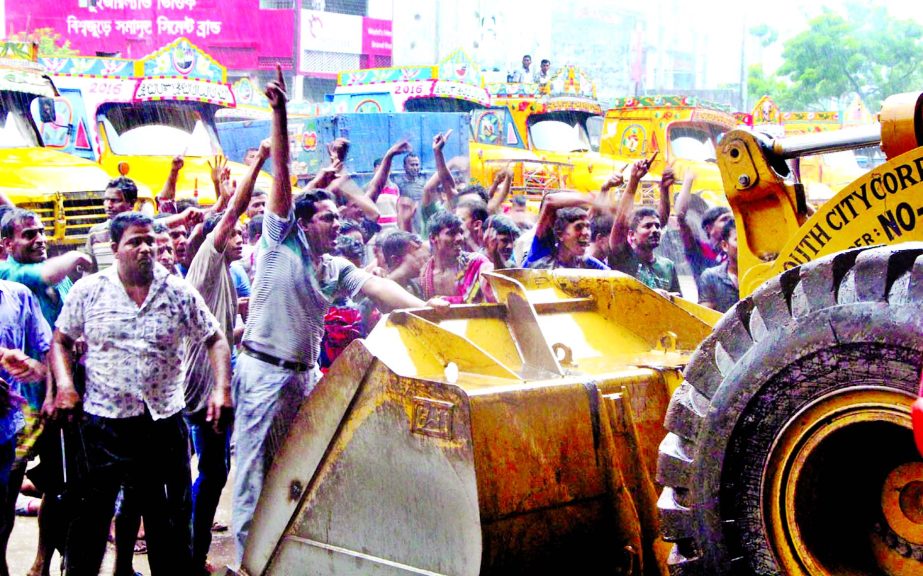 Truck drivers, workers in scuffling while DSCC authority trying to evict illegal possessions of land using as truck depot for long at Saidabad area in city on Thursday.