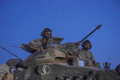 Turkish soldiers stand in an army tank driving back to Turkey from the Syrian-Turkish border town of Jarabulus.