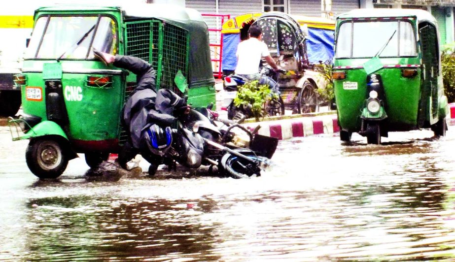 Photo shows a motor rider rammed onto CNG auto rickshaw in a road plugged by water logging and potholes in Port city Chittagong's Agrabad area on Friday.
