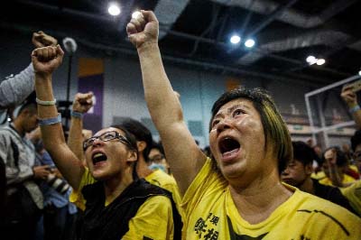 Supporters celebrate the win of Civic Passion's Cheng Chung-tai in the Legislative Council election, at the central counting station in Hong Kong.