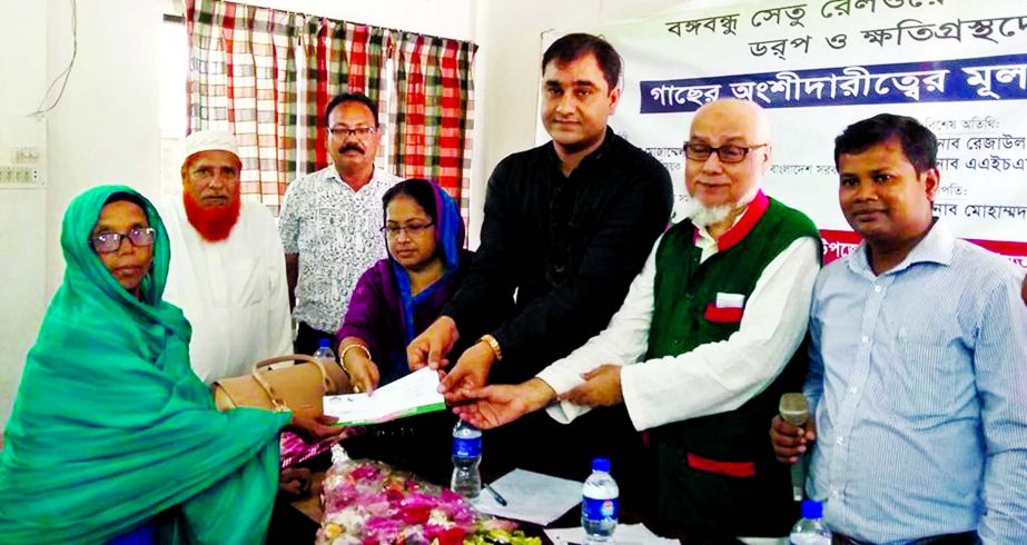 AHM Nouman, CEO of DORP, a non government organization, and GUSI International Peace Laureate is seen along with Rezaul Karim Rasel, Chairman of Kaliakoir Upazila, Gazipur handing over cheques among the local people who are affected due to building rail l