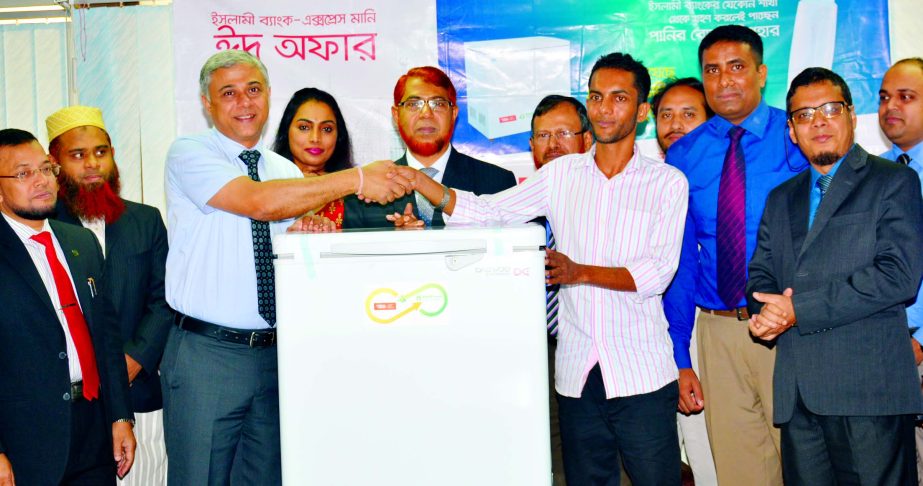 Abdus Sadeq Bhuiyan, Deputy Managing Director and Head of International Banking Wing of Islami Bank Bangladesh Limited and Arvind Mylar, Vice President- Business Development of Xpress Money handing over a deep freezer to Md. Mukul Hossain, a customer of t
