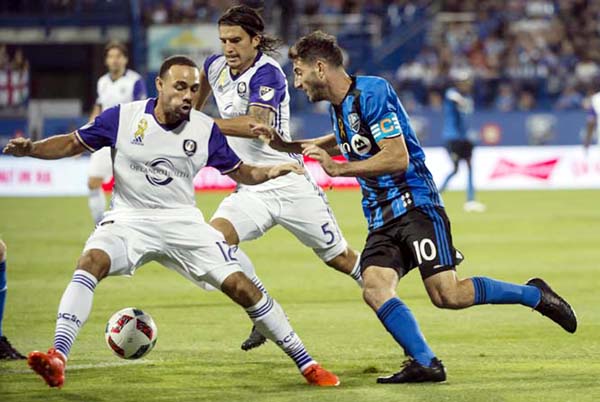Montreal Impact midfielder Ignacio Piatti (right) battles Orlando City FC defender Kevin Alston (left) and midfielder Servando Carrasco for the ball during the first half of an MLS soccer game in Montreal on Wednesday.