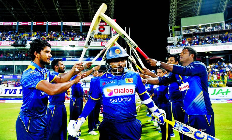 Sri Lankan cricketer Tillakaratne Dilshan (C) receives a farewell from his teammates after declaring his retirement from T20 International cricket at the start of the final T20 international cricket match between Sri Lanka and Australia at the R. Premadas