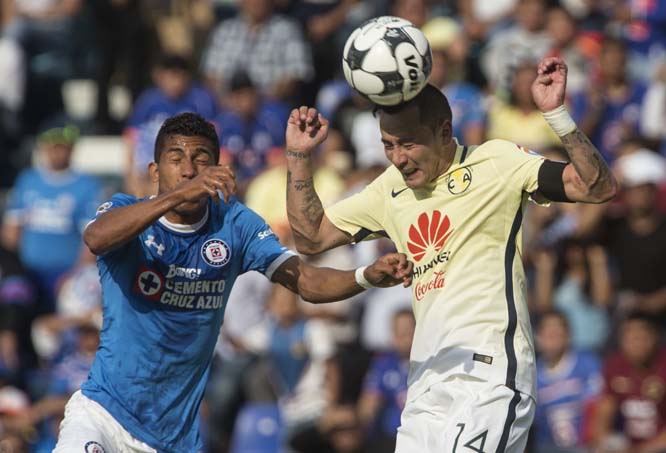 America's Rubens Sambueza (right) heads the ball pressured by Cruz Azul's Roque Santa Cruz during a Mexican soccer league match in Mexico City on Saturday.