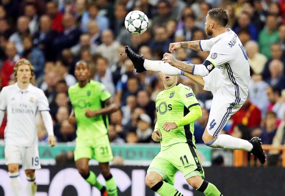 Real Madrid's Sergio Ramos jumps for the ball next to Sporting's Bruno Cesar during a Champions League, Group F soccer match between Real Madrid and Sporting, at the Santiago Bernabeu stadium in Madrid, Spain on Wednesday.