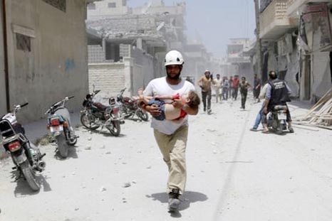 A civil defence member carries an injured baby at a site hit by airstrikes in the rebel-controlled area of Maaret al-Numan town in Idlib province, Syria.