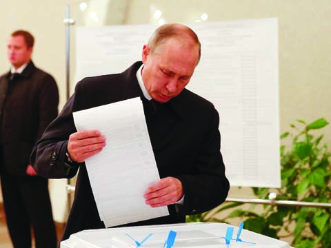 Russian President Vladimir Putin casts his ballot during parliamentary elections in Moscow on Sunday.