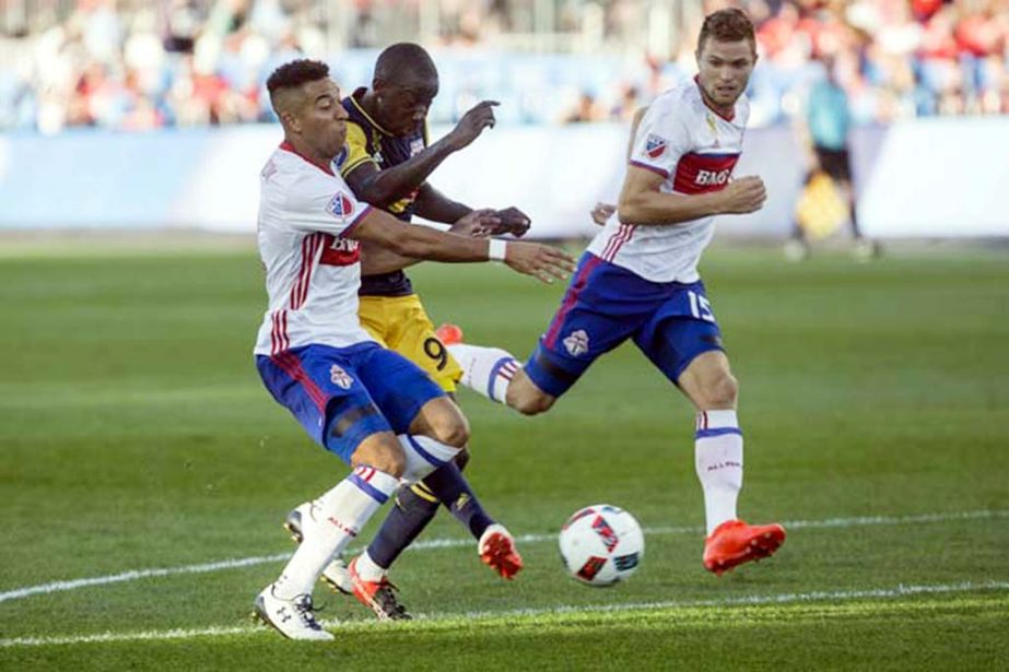 New York Red Bulls forward Bradley Wright-Phillips (center) gets a shot away at goal under pressure from Toronto FC's Justin Morrow, left, and teammate Eriq Zavaleta during second half MLS soccer action in Toronto on Sunday.