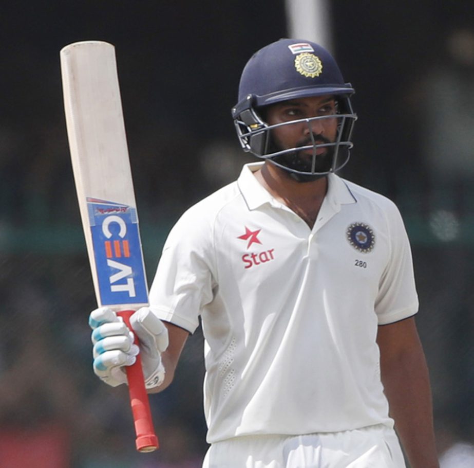 India's Rohit Sharma raises bat after scoring fifty runs on the fourth day of their first cricket Test match against New Zealand at Green Park Stadium in Kanpur, India on Sunday.
