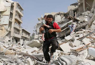 A Syrian man carries a baby after removing him from the rubble of a destroyed building following a reported air strike in the Qatarji neighbourhood of the northern city of Aleppo