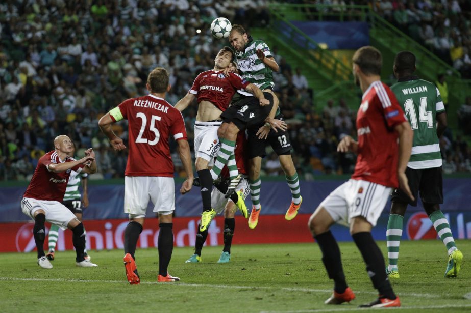 Sporting's Bas Dost (center right) jumps to head the ball during a Champions League, Group F soccer match between Sporting and Legia Warsaw at the Alvalade stadium in Lisbon on Tuesday.