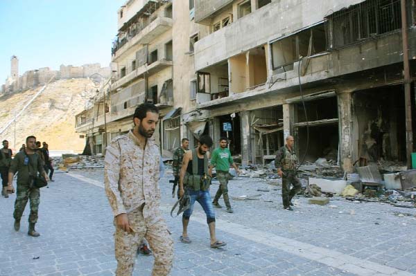 Syrian pro-government forces patrol the Farafira district, Aleppo, after taking control of the rebel-held area following days of heavy air strikes.