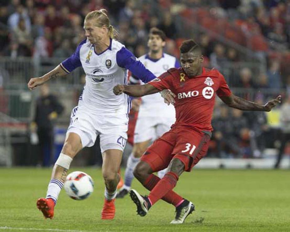 Toronto FC's Amando Cooper (right) gets a shot on goal despite pressure from Orlando City's Brek Shea during the second half of a soccer game in Toronto on Wednesday.