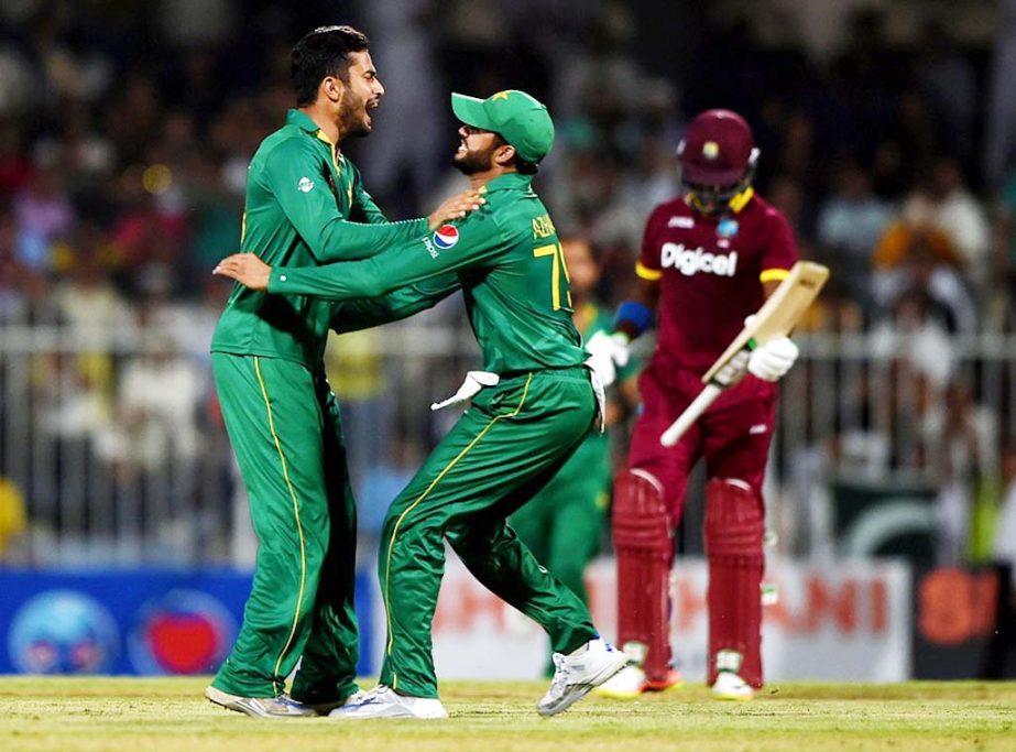 Muhammad Nawaz (L) of Pakistan celebrates with Azhar Ali (R) taking the wicket of Darren Bravo of West Indies during the first One Day International match between Pakistan and West Indies at Sharjah Cricket Stadium in Sharjah, United Arab Emirates on Frid