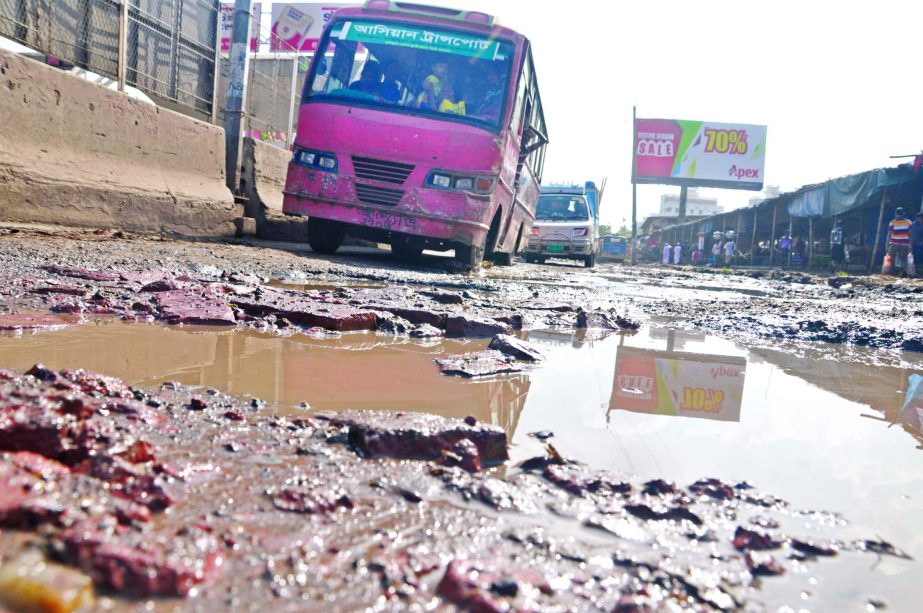 As big potholes and ditches developed on the road connecting Hanif Flyover adjacent to Kajla area in city for a long time, vehicles struggle to move thru' it. This photo was taken on Saturday.