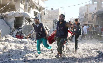 Volunteers carry an injured person following Syrian government forces airstrikes in Aleppo.