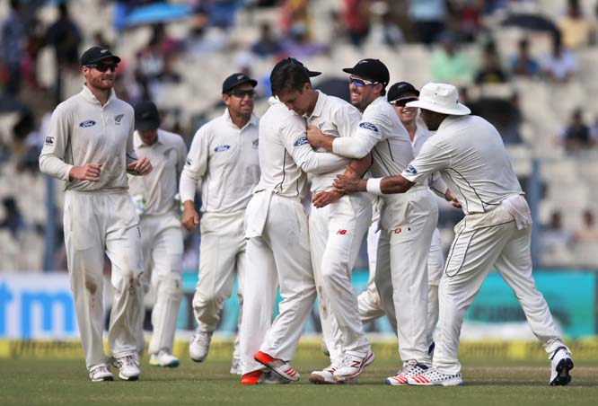 New Zealand's Trent Boult (fourth from right) celebrates with teammates after taking the wicket of India's Virat Kohli on the third day of their second cricket Test match in Kolkata, India on Sunday.