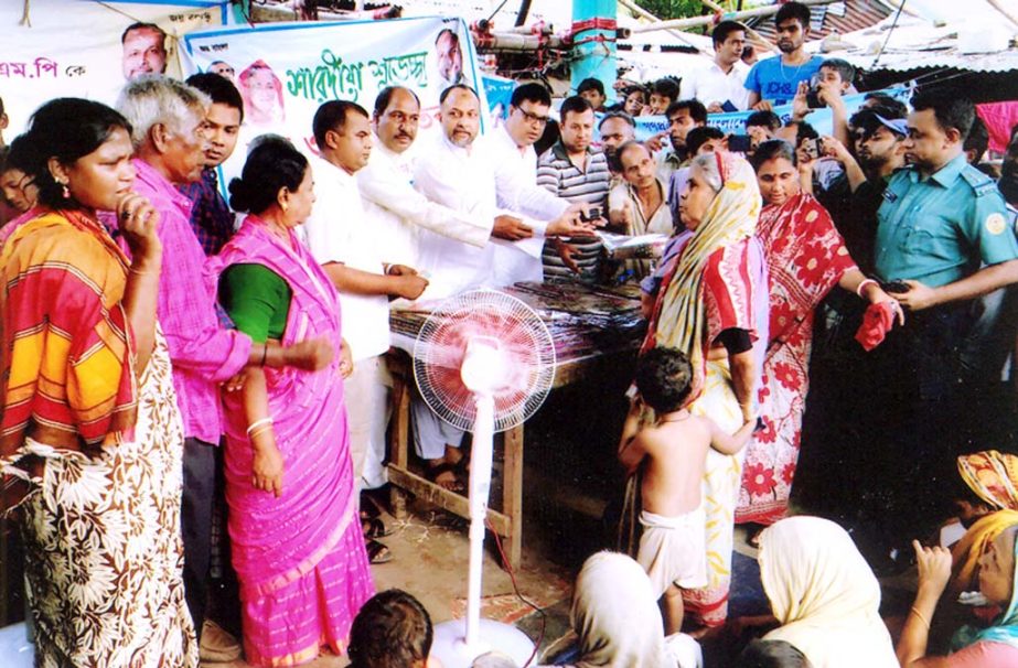 M A Latif MP distributing rice and clothes among the poor people in port city ahead of Durga Puja recently.