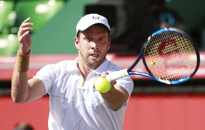 Gilles Muller of Luxembourg returns a shot to Marcos Baghdatis of Cyprus during their second round match of the Japan Open tennis tournament in Tokyo on Thursday.