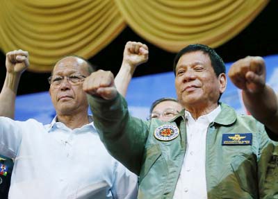 Philippine President Rodrigo Duterte, centre, poses with a fist bump with Defense Chief Delfin Lorenzana, left, during his "Talk with the Airmen" on the anniversary of the 250th Presidential Airlift Wing, at the Philippine Air Force headquarters in subu