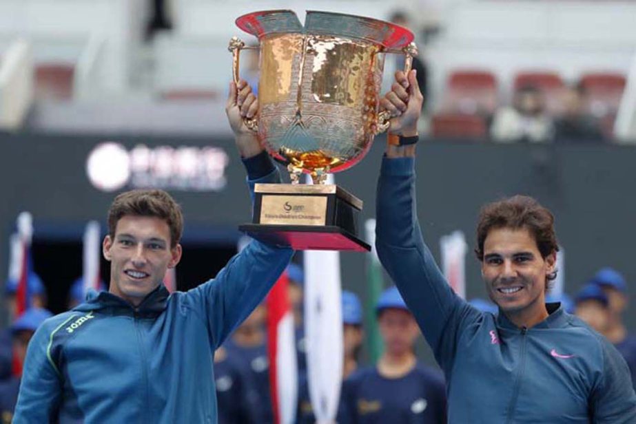 Rafael Nadal, right, and Pablo Carreno Busta of Spain pose with their winning trophy after defeating Jack Sock of the United States and Bernard Tomic of Australia in the men's doubles match at the China Open tennis tournament in Beijing on Sunday.