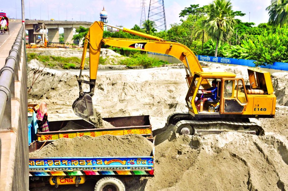 Influential syndicate still using bulldozer to illegally extract sand from beneath the Sultana Kamal Bridge at Demra. This photo was taken on Sunday.