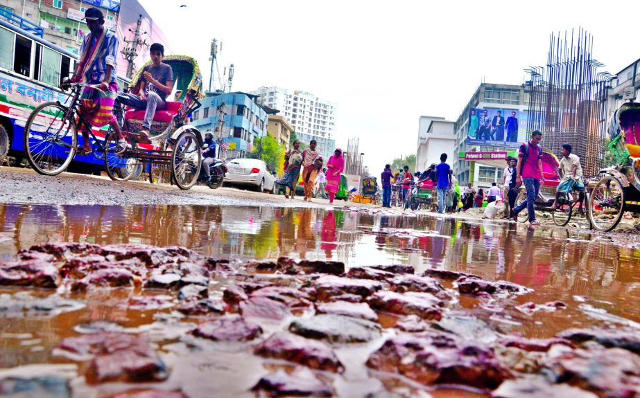 The main thoroughfare in city's Malibagh area has numerous potholes and cracks causing sufferings to commuters and pedestrians. This road is frequently repaired as an eyewash when Minister Obaidul Quader visits the site. This photo was taken on Monday.