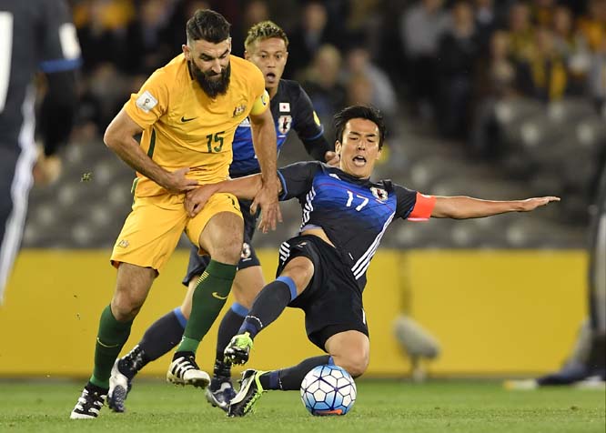 Japan's Makto Hasebe (right) attempts to take the ball from Australia's Mile Jedinak during their World Cup qualifying match in Melbourne, Australia on Tuesday.