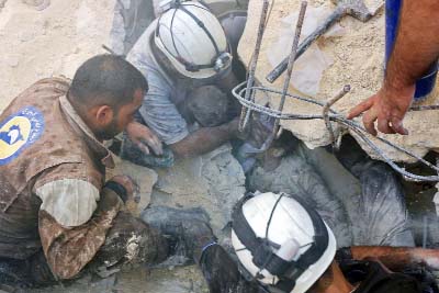 A Syrian boy receives oxygen from civil defence volunteers, known as the white helmets, as they rescue him from under the rubble of a building following Russian air strikes in Aleppo.