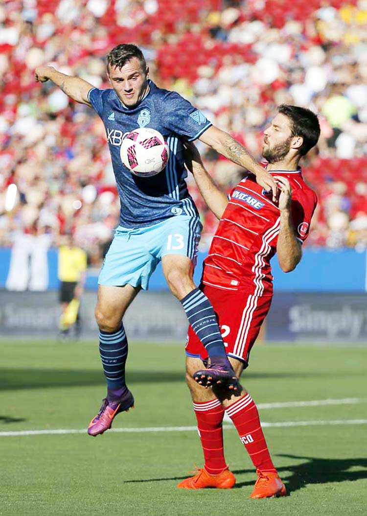 Seattle Sounders forward Jordan Morris (13) attempts to gain control of the ball in front of FC Dallas midfielder Ryan Hollingshead (right) in the first half of an MLS soccer match in Frisco, Texas on Sunday.