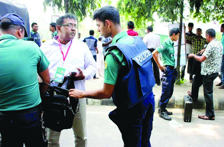 Law enforcers checking people at the entrance of Suhrawardy Udyan for the security measures on the occasion of 20th Council of Bangladesh Awami League. The snap was taken from Doel Chattar in the city on Saturday.