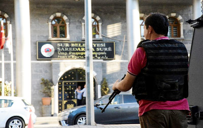 A Turkish policeman stands guard at the Sur municipality building during a police operation