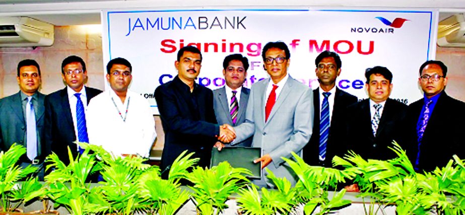 AKM Saifuddin Ahamed, Deputy Managing Director of Jamuna Bank Ltd and AKM Mahfuzul Alam, Manager (Sales and Marketing) of NOVOAIR, exchange documents after signing a agreement at banks head office in the city recently. Under the agreement, employees of th