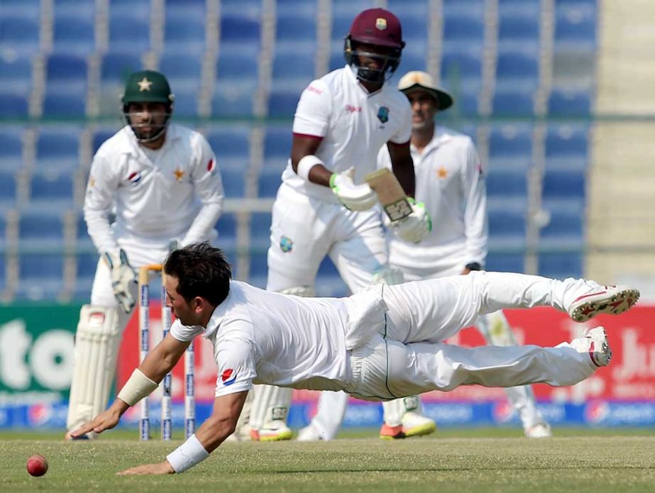 Yasir Shah attempts to field off his own bowling on the 4th day of 2nd Test between Pakistan and West Indies at Abu Dhabi on Monday.