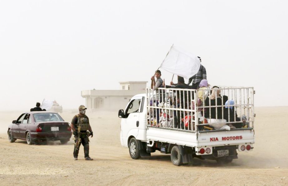 A member of Iraq's elite counterterrorism forces watches a truck carrying fleeing civilians drive off, as Iraq's elite counterterrorism forces fight against Islamic State militants, in the village of Tob Zawa, about 9 kilometres (5.6 miles) from Mosul,