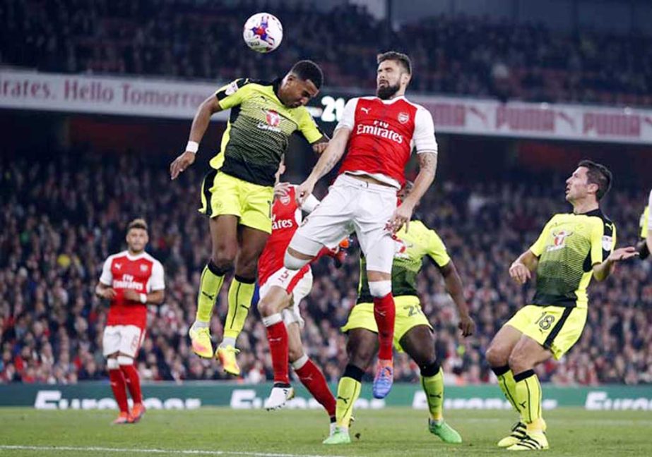 Arsenal's Olivier Giroud (right) heads a shot past Reading's Liam Moore during the English League Cup soccer match between Arsenal and Reading at Emirates stadium in London on Tuesday.
