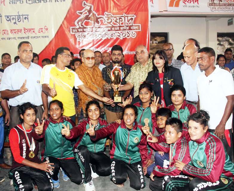Food Minister Advocate Kamrul Islam with the women's division National Wrestling champions Bangladesh Ansar team at Shaheed Captain M Mansur Ali Handball Stadium on Monday.