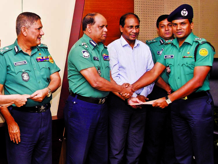 DMP Police Commissioner Asaduzzaman Miah, among others, at the crest of honour giving ceremony to Senior Assistant Deputy Police Commissioner Md Zahangir Alam at DMP Headquarters on Thursday for his role in proper traffic management.