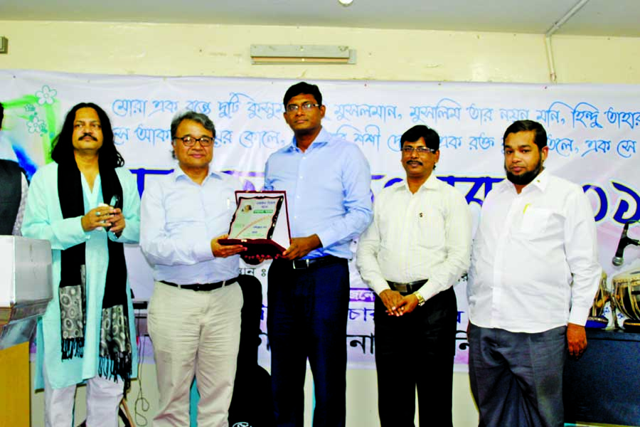 Prof Salimullah Khan being handed over a crest at a ceremony organised by Dhaka International University Cultural Club on its Green Road campus in the city on Wednesday on the occasion of Nazrul Festival-2016.