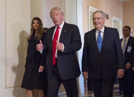 President-elect Donald Trump, flanked by his wife, Melania, and Senate Majority Leader Mitch McConnell of Ky., gives a thumbs-up on Capitol Hill in Washington.